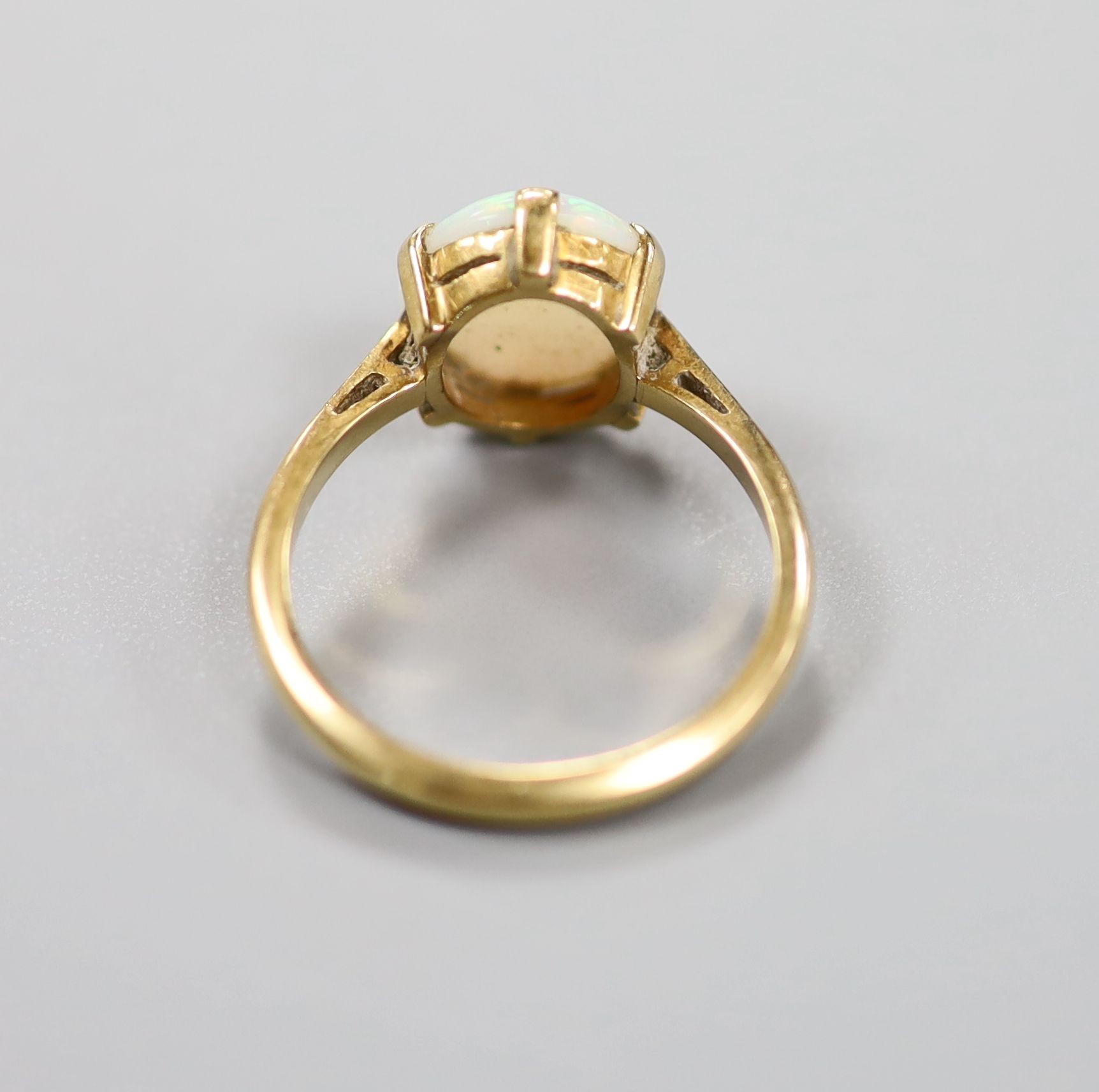 An 18ct and oval white opal set ring, size N, gross weight 3.6 grams.